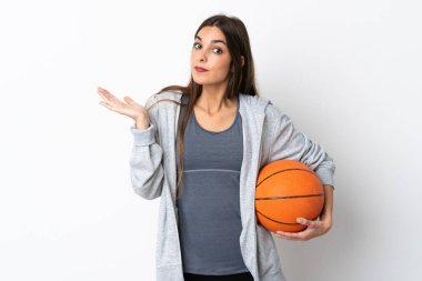 Basketbol oynayan genç bir kadın, beyaz arka planda izole edilmiş, şüphe içinde el kaldırırken...