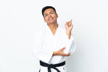 Ekvador 'lu genç bir adam beyaz arka planda karate yapıyor. En iyinin işareti olarak parmağını kaldırıyor.