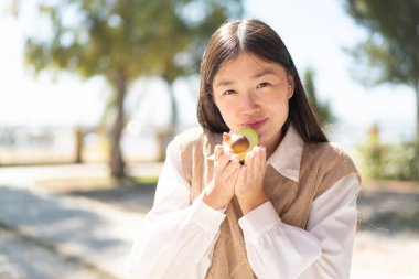 Avokado tutan güzel bir Çinli kadın.