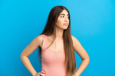 Mavi arka planda izole edilmiş beyaz bir kadın. Taraf ararken şüphe duyuyor.