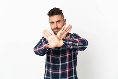 Beyaz arka planda izole edilmiş beyaz bir adam bir eylemi durdurmak için eliyle dur hareketi yapıyor.