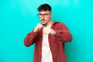 Kafkasyalı yakışıklı genç adam mavi arka planda izole edildi.