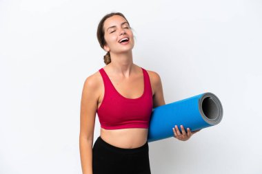 Beyaz arka planda izole edilmiş bir minderi tutarken yoga derslerine giden beyaz bir kadın.