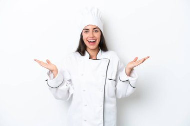 Beyaz arka planda genç aşçı kadın şok olmuş yüz ifadesi ile