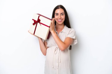 Beyaz arka planda izole edilmiş beyaz bir kadın hamile ve elinde bir hediye var.