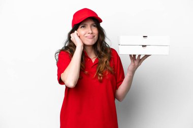 İş üniformalı pizzacı kadın beyaz arka planda izole edilmiş pizza kutuları alıyor hayal kırıklığına uğramış ve kulaklarını kapatıyor.