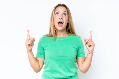 Beyaz arka planda izole edilmiş genç beyaz kadın şaşırmış ve yukarı bakıyor.