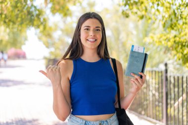 Young caucasian woman with hair comb isolated on white background pointing to the side to present a product