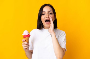 Sarı arka planda izole edilmiş kornet dondurmalı beyaz bir kadın ağzı açık bağırıyor.
