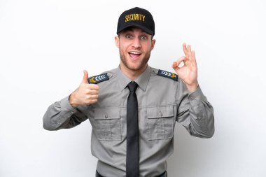 Beyaz arka planda izole edilmiş genç bir güvenlik görevlisi tamam işareti ve baş parmak hareketi gösteriyor.
