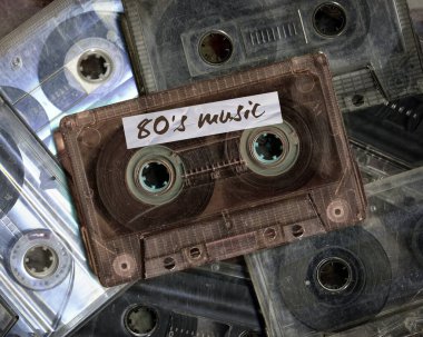 Yan yana yerleştirilmiş klasik ses kasetleri var. Ses kaydı ve kayıt formatının eskimiş teknolojisi ses kasetleri, üst görünüm. 80 'lerin retro müzik arkaplanı.