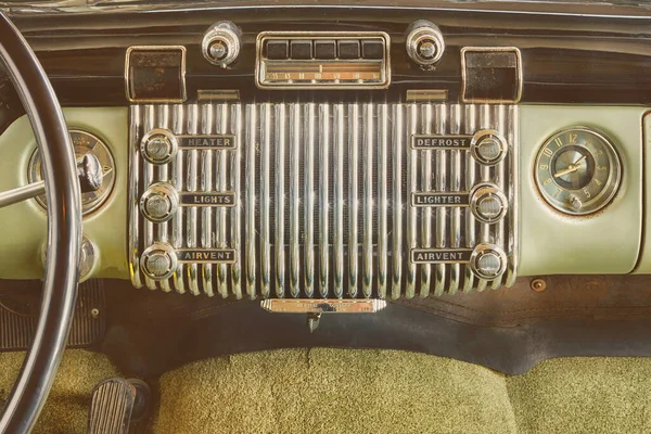 Old car radio inside a classic American car with chrome dashboard