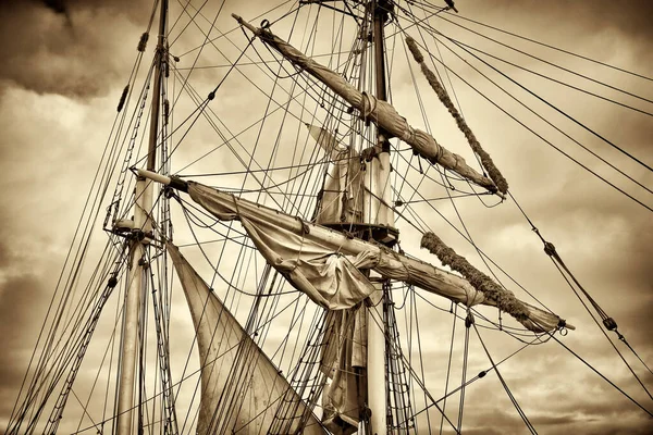 Sepia toned image of masts and sails of an ancient sailing ship