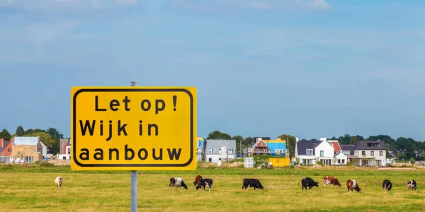 在荷兰一个新建房屋的草地前面 有一个交通标志 上面有荷兰语 正在建设的住宅区 — 图库照片