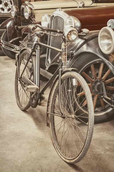 Vintage bicycle in front of classic early twentieth century cars