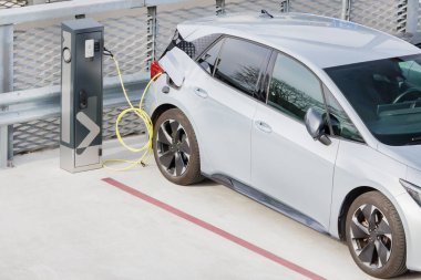 Hollanda 'da park yerinde gümüş rengi arabası olan elektrikli bir araba için EV şarj istasyonu