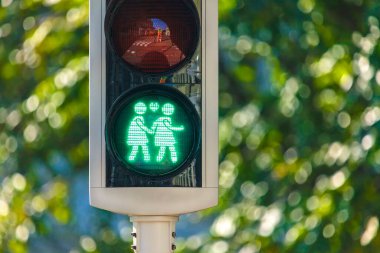 Hollanda trafik lambası gökkuşağı geçidinde aynı cinsiyetten çiftin kalp sembolüyle el ele yürümesi.