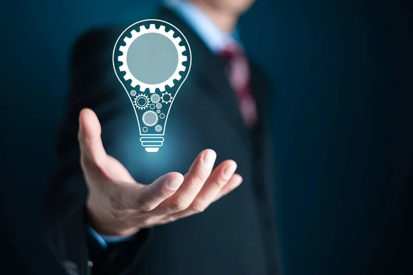 İş adamı Hands, yenilik ve ilham içeren yeni bir fikir kavramı, bilim ve iletişim kavramında yenilikçi bir teknoloji için ampul tutuyor. Yenilik kavramı