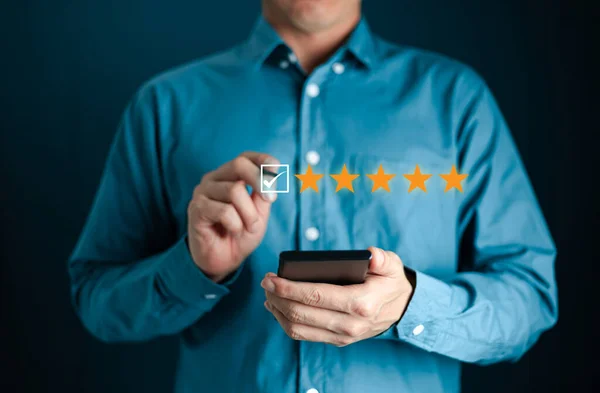 Business Man, geri bildirim değerlendirme memnuniyet servisi, müşteri hizmetleri deneyimi ve iş memnuniyeti anketi için beş yıldızlı simgeye dokunuyor. en kaliteli ürün ve hizmet