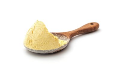 Pile of corn flour in wooden measuring spoon on white background