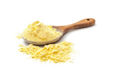 Corn flour poured from wooden spoon on white background