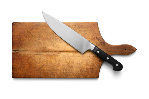 Big kitchen knife lying on an old cutting board isolated on white, including clipping path