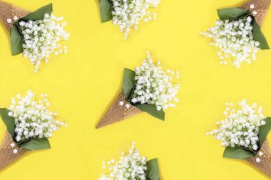 Sarı arka planda vadi zambağı olan dondurma külahı. Şablon. Düz yatıyordu. Üst görünüm.