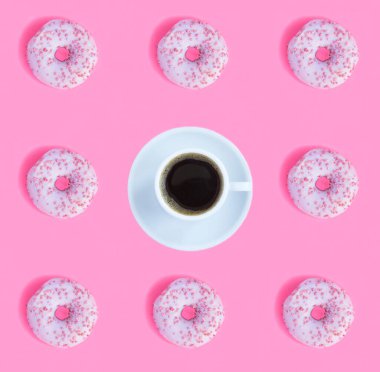 Pembe jöleli çörek ve pembe arka planda kahve fincanı. Düz yatıyordu. Şablon. Üst görünüm.