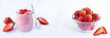 Natural milk yogurt with strawberry in the glass jar on the white background. Copy space. Banner.