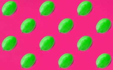 Green lemon on the bright pink background. Flat lay. Pattern. Top view.