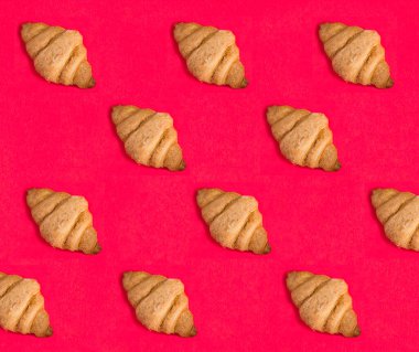 Croissants on the red background. Pattern. Flat lay.