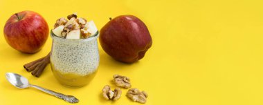 Sarı arka planda chia tohumu, elma, tarçın ve cevizli puding. Uzayı kopyala Yakın plan..