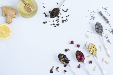 Beyaz arka planda gümüş kaşıklarda kurutulmuş bitki çayı. Üst Manzara. Boşluğu kopyala.