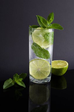 Siyah arka plandaki içki bardağında mojito kokteyli. Yakın plan..