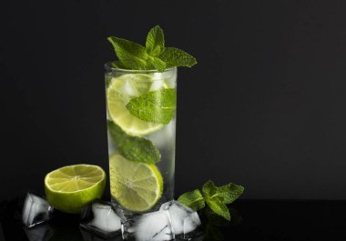 Siyah arka plandaki içki bardağına mojito kokteyli. Boşluğu kopyala. Yakın plan..