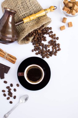 Kahverengi fincanda sade kahve, beyaz arka planda kahve çekirdeği ve şeker. Üst Manzara. Konum dikey.