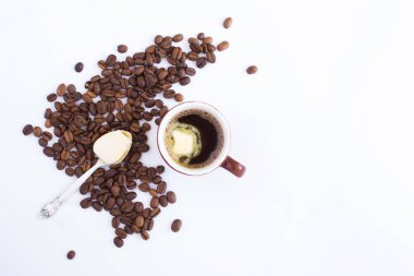 Beyaz arka plandaki fincanda tereyağlı kahve. Üst Manzara. Boşluğu kopyala.