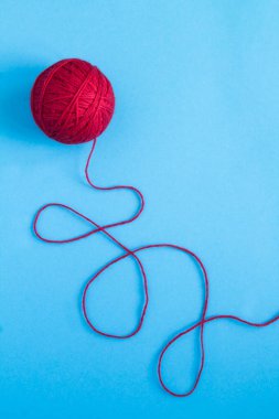 Mavi arka planda örgü örmek için kırmızı iplikler. Üst Manzara. Boşluğu kopyala.