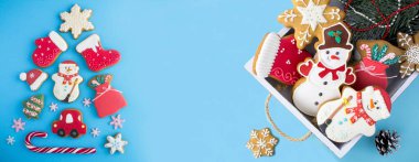 Zencefilli çörekten Noel ağacı ve mavi arka plandaki beyaz ahşap tepside zencefilli ekmek. Uzayı kopyala Üst görünüm.
