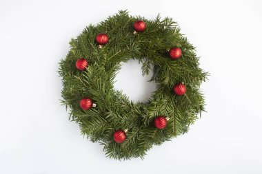 Beyaz arka planda kırmızı boncuklu Noel yüzüğü ya da çelenk. Üst Manzara. Yakın plan..