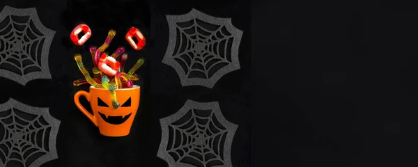 Orangefarbene Tasse Mit Süßigkeiten Für Halloween Auf Schwarzem Hintergrund Kopierraum — Stockfoto