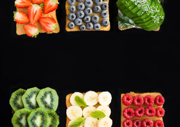 Sandwiches with fruit, berry and vegetable on the black background. Copy space.Top view.