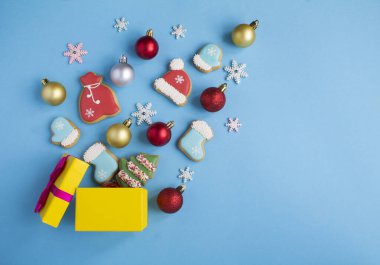 Mavi arka planda renkli boncuklar ve zencefilli ekmekler olan Noel hediyesi kutusu. Uzayı kopyala Üst görünüm.