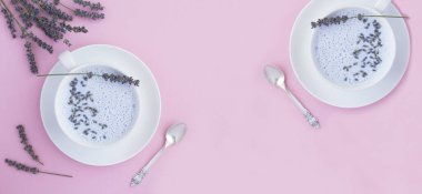 Pembe arka planda beyaz bardaklarda lavantalı ay sütü. Uzayı kopyala Üst görünüm.