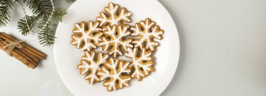 Gri arka plandaki tabakta kar taneleri şeklinde Noel zencefilli ekmek. Üst Manzara. Boşluğu kopyala.