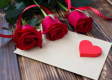 Sevgililer Günü için arka plan. Ahşap arka planda kırmızı kalp ve güller. Yakın plan..