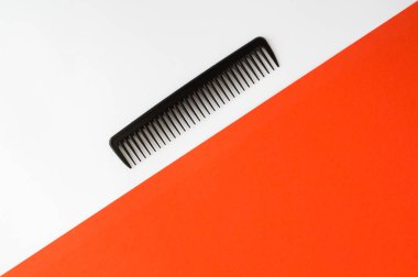 Beyaz ve kırmızı arkaplanda siyah tarak. Üst manzara. Boşluğu kopyala.