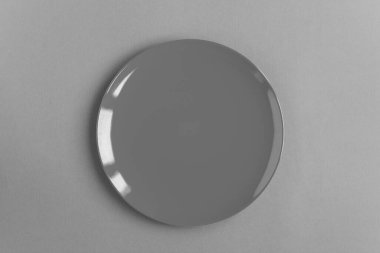 Gri arka planda boş gri plaka. Üst Manzara. Uzayı kopyala Yakın plan..