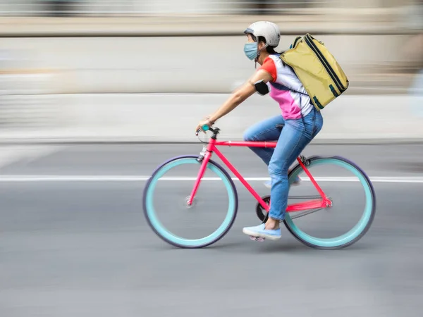 街の通りを自転車で移動中の宅配便のぼやけたシルエット — ストック写真