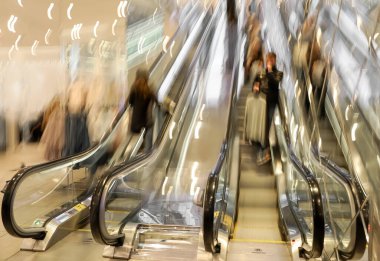 Alışveriş merkezindeki yürüyen merdivenlerdeki insanların bulanık görüntüsü